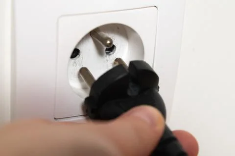 Attentively attaching plug to socket with focus on safety measures Stock Photos