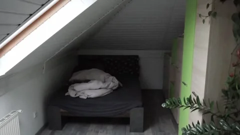 Attic Bedroom Interior with Unmade Bed and Green Wardrobe. Stock Footage 324703673