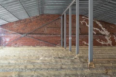 Attic of a house under construction with insulation on the floor. Pipes. Bric Stock Photos