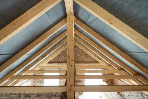 Attic space of a building under construction with wooden beams of a roof stru Stock Photos