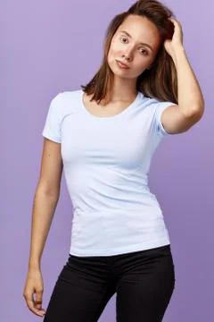 Attracative girl in white t-shirt and jeans with raised arm posing to the camera Stock Photos