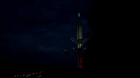 Attraction carousel on a long stock, multi-colored with light bulbs in the night Stock Footage 112419858