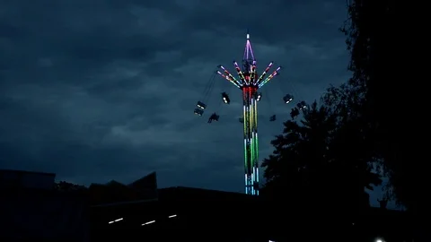Attraction carousel on a long stock, multi-colored with light bulbs in dark time Stock Footage 112419911