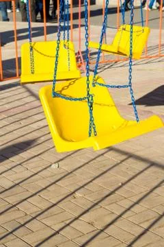 Attraction yellow swing on a chain Stock Photos