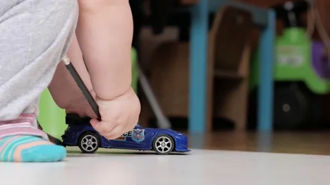 Attractive 2 year old boy playing with police car at home Stock Footage 73964361
