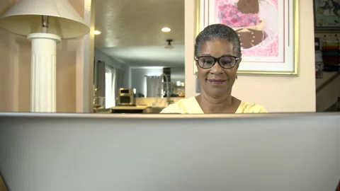 Attractive african american lady senior looking at computer smiling Stock Footage