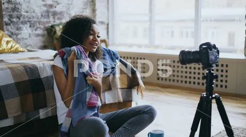 Attractive african girl recording video blog about her wardrobe for travel with Stock Photos