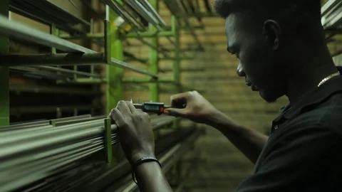 Attractive african guy warehouse worker caliper measures the thickness of Stock Footage 126397369