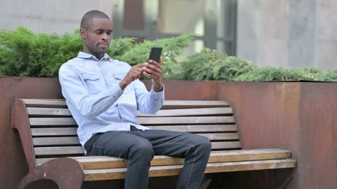 Attractive African Man using Smartphone Outdoor Stock Footage 136033106