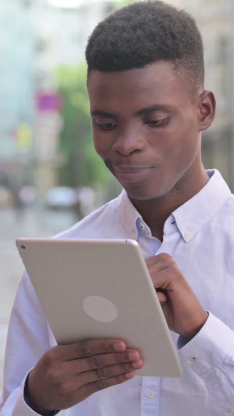 Attractive African Man using Tablet in Street, Vertical Video Stock Footage 340024644