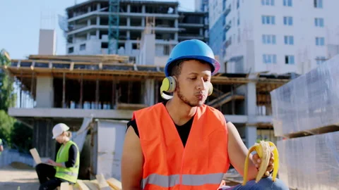 Attractive Afro American guy construction worker have a break time eating a Stock Footage 141184428