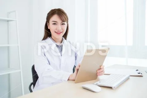 Attractive aisan doctor working in office Stock Photos