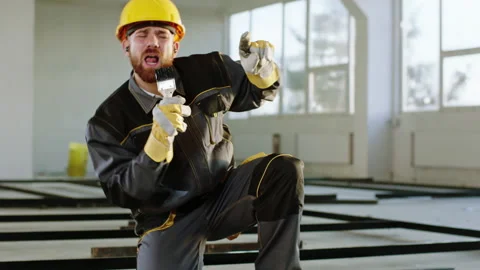 Attractive and exciting constructor worker at construction site using a painting Stock Footage 170149305