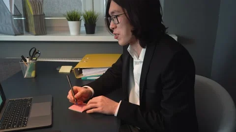 Attractive Asian Guy Studying on-line Making Video Call Writing a Note Stock Footage 148344148