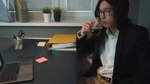 Attractive Asian Guy talking on Video Call Drinking Coffee Stock Footage 148344207