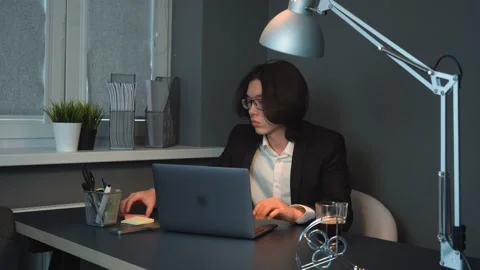 Attractive Asian Guy at Work Writing a Note Late at Night Stock Footage 148365598