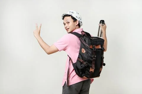 Attractive asian man backpacker backpose holding tumbler bottle give victor.. Stock Photos