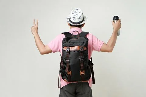 Attractive asian man backpacker backpose holding tumbler bottle give victor.. Stock Photos