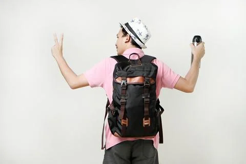 Attractive asian man backpacker backpose holding tumbler bottle give victor.. Stock Photos