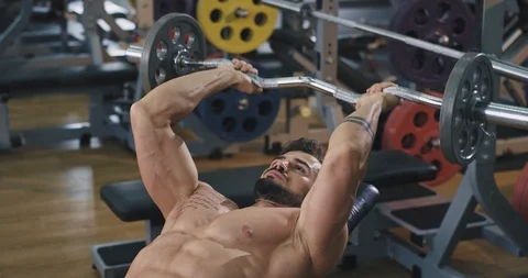 Attractive athletic man doing his hard workout lifting the weights at the gym Stock Footage 114763357