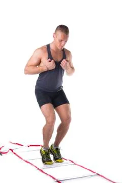 Attractive athletic young man working out with agility ladder on white Stock Photos