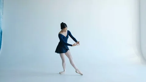 Attractive ballerina performs professional dance elements on a white background Stock Footage 119073831