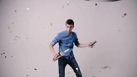 Attractive bartender professionally juggling cups and bottles and doing a show Stock Footage 164873993