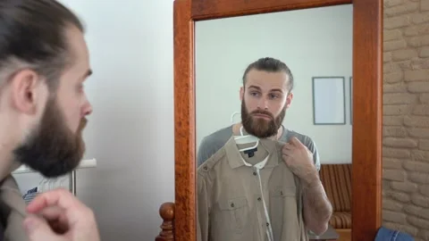 Attractive beard man,  Putting together an outfit with new shirt Stock Footage 147895276