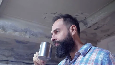 Attractive bearded guy smokes a cigarette and drinks coffee from a metal cup Stock Footage 116474510
