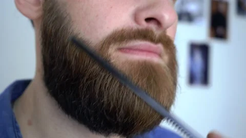 Attractive bearded man is Combing His Beard close up Stock Footage 147898989