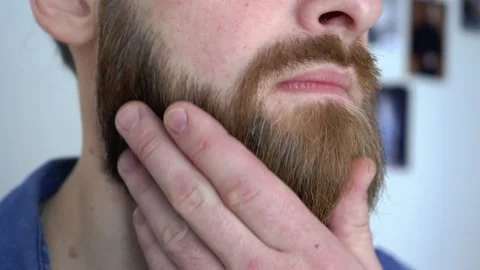 Attractive bearded man is Combing His Beard closeup Stock Footage 147899151