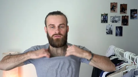 Attractive bearded man is taking t-shirt off Stock Footage 147900500
