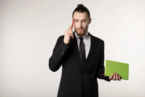 Attractive bearded middle manager is thinking how to solve the problem posed by Stockfoto's
