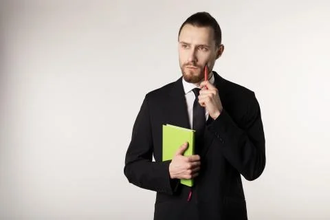 Attractive bearded middle manager is thinking how to solve the problem posed by Stock Photos