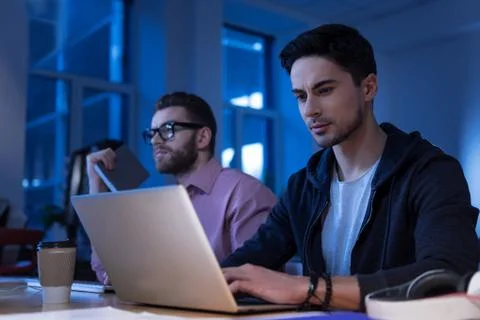 Attractive bearded programmer typing on the laptop Stock Photos