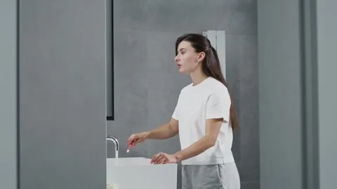 Attractive beautiful female brushing teeth with toothbrush and toothpaste Stock Footage 251552879