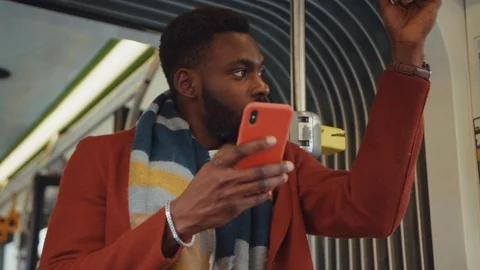 Attractive black bearded man using mobile phone smiling reading great news or Stock Footage 121475647