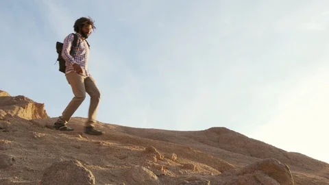 Attractive black male with dreadlocks going down on a cliff at sunrise Stock Footage 101368475
