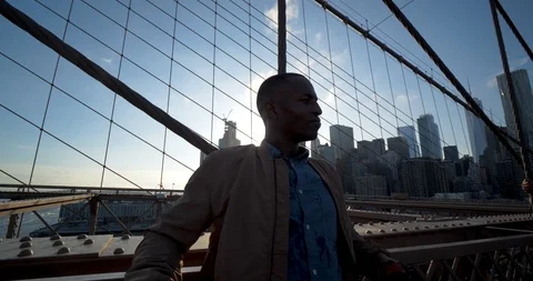 Attractive Black Man on Brooklyn Bridge, Lens Flare Sunset NYC Skyline 스톡 동영상 102401656