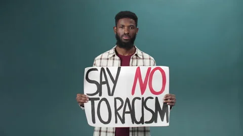 An attractive black man stands and shows a poster against racism Stock Footage 170800045