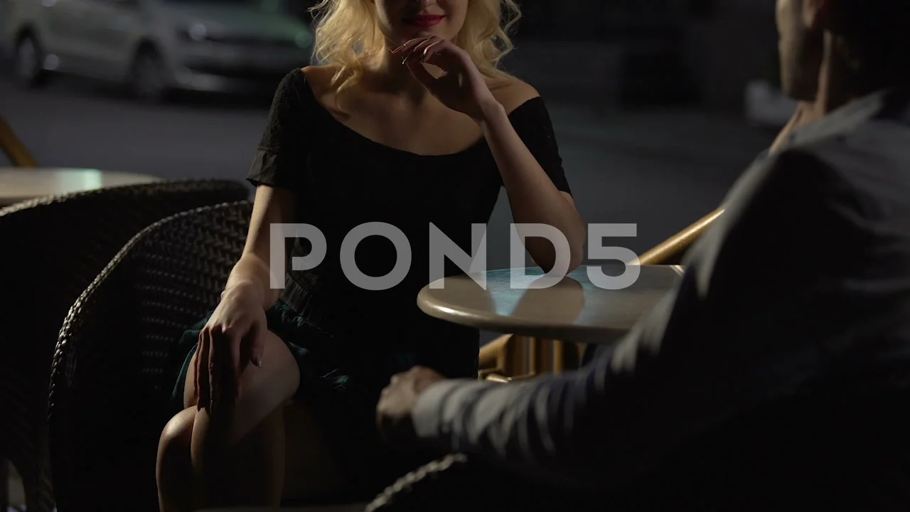 Attractive blond female seducing man on restaurant terrace, escort service