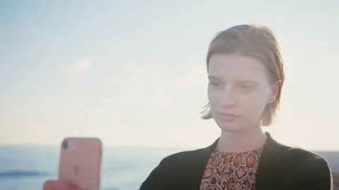 Attractive blond lady making selfie with phone on the beach, stylish haircut Stock Footage 105599306