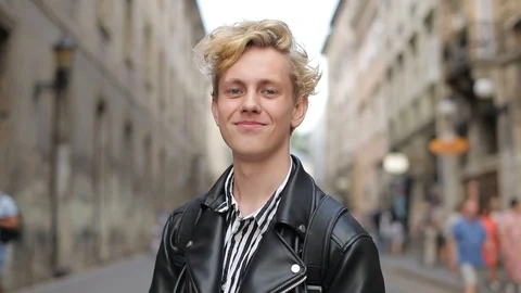 Attractive blond stands looking at the camera, then turns around and walks away Vídeo Stock 126576952