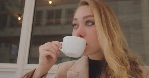 Attractive blonde drinking cup of coffee in Paris, France, close up view Stock Footage 233316420