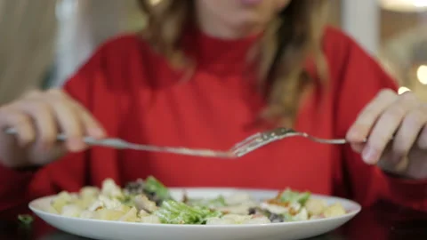 Attractive blonde eats at a cafe a salad with chicken in a cafe. Video stock 103702713