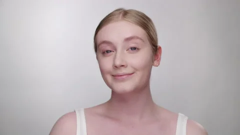 Attractive blonde model looks into camera as she admires her makeup in mirror Stock Footage 193679415