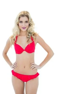 Attractive blonde model posing with hands on hips wearing bikini Stock Photos