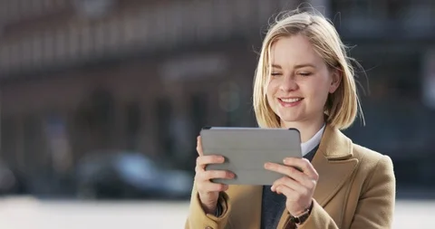 Attractive blonde using her tablet outside on the street Stock Footage 106034820