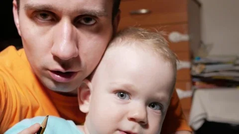 An attractive boy 2 years old and a father doing selfies. Smile and look at the Stock Footage 73842831