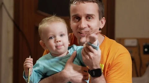 An attractive boy 2 years old and a father doing selfies. Smile and look at the Stock Footage 73842995